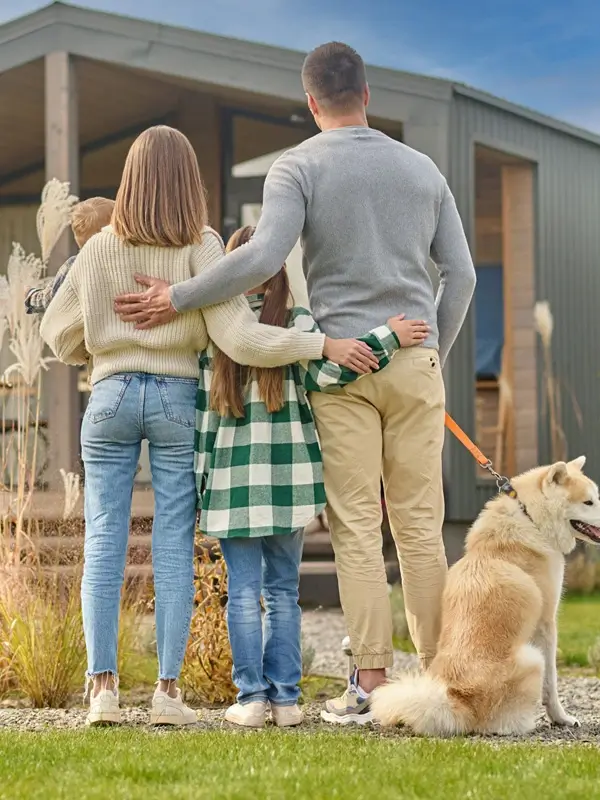 Family with children and dog standing with back to camera